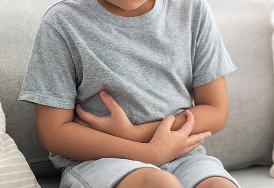 Sick boy touching belly stomach