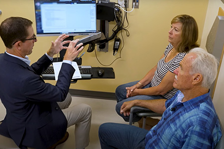 Urologic surgeon Marc Dall&rsquo;Era explaining to a couple about prostate cancer.