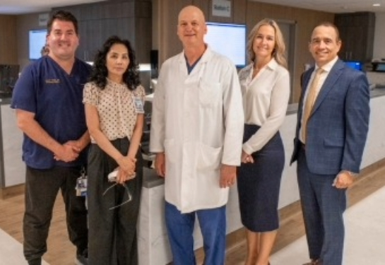 Five people standing in front of nurses station in emergency department.