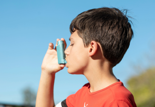 Boy breathing in from an inhaler.