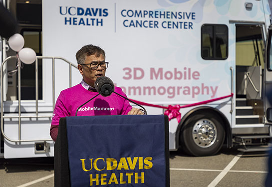 Man with dark hair wearing pink shirt that reads, "MobileMammo+"