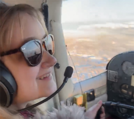 Tiffany Balts wearing sunglasses and flying a Cessna 150.